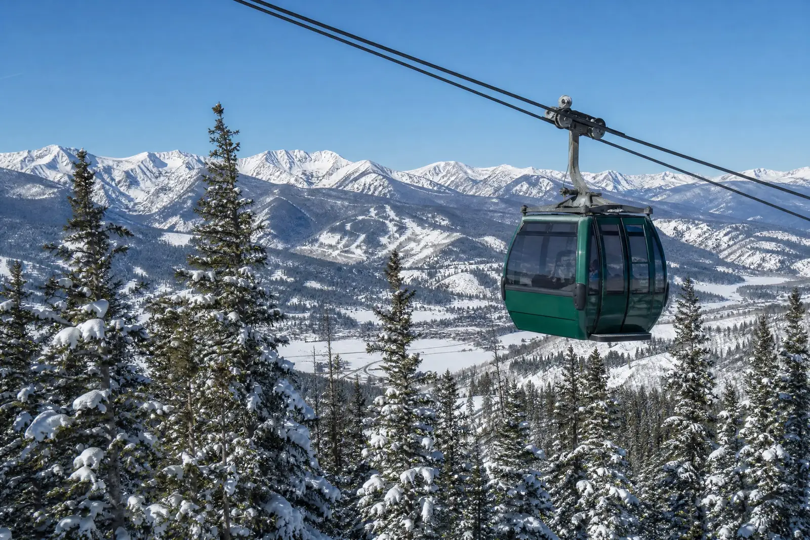 The Alders, Keystone gondola over snow-covered pines and peaks in winter, luxury vacation rental in Keystone, Colorado