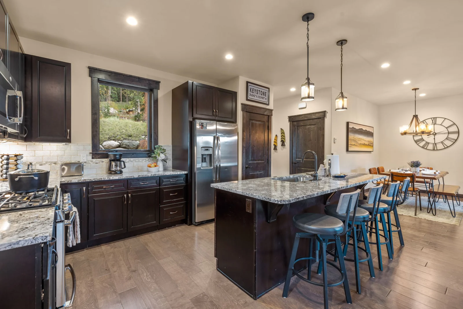 The Alders, Kitchen island with blue stools and dining area beyond, luxury vacation rental in Keystone, Colorado