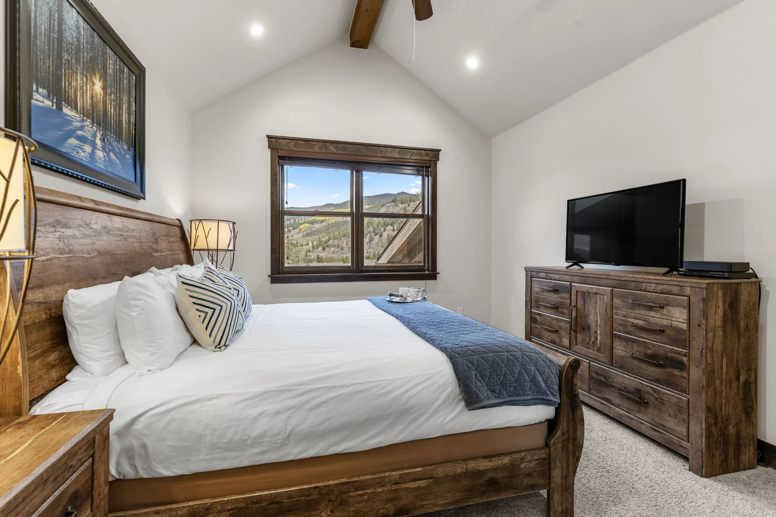 The Alders, Bedroom with wood bed and television beneath vaulted ceiling, luxury vacation rental in Keystone, Colorado
